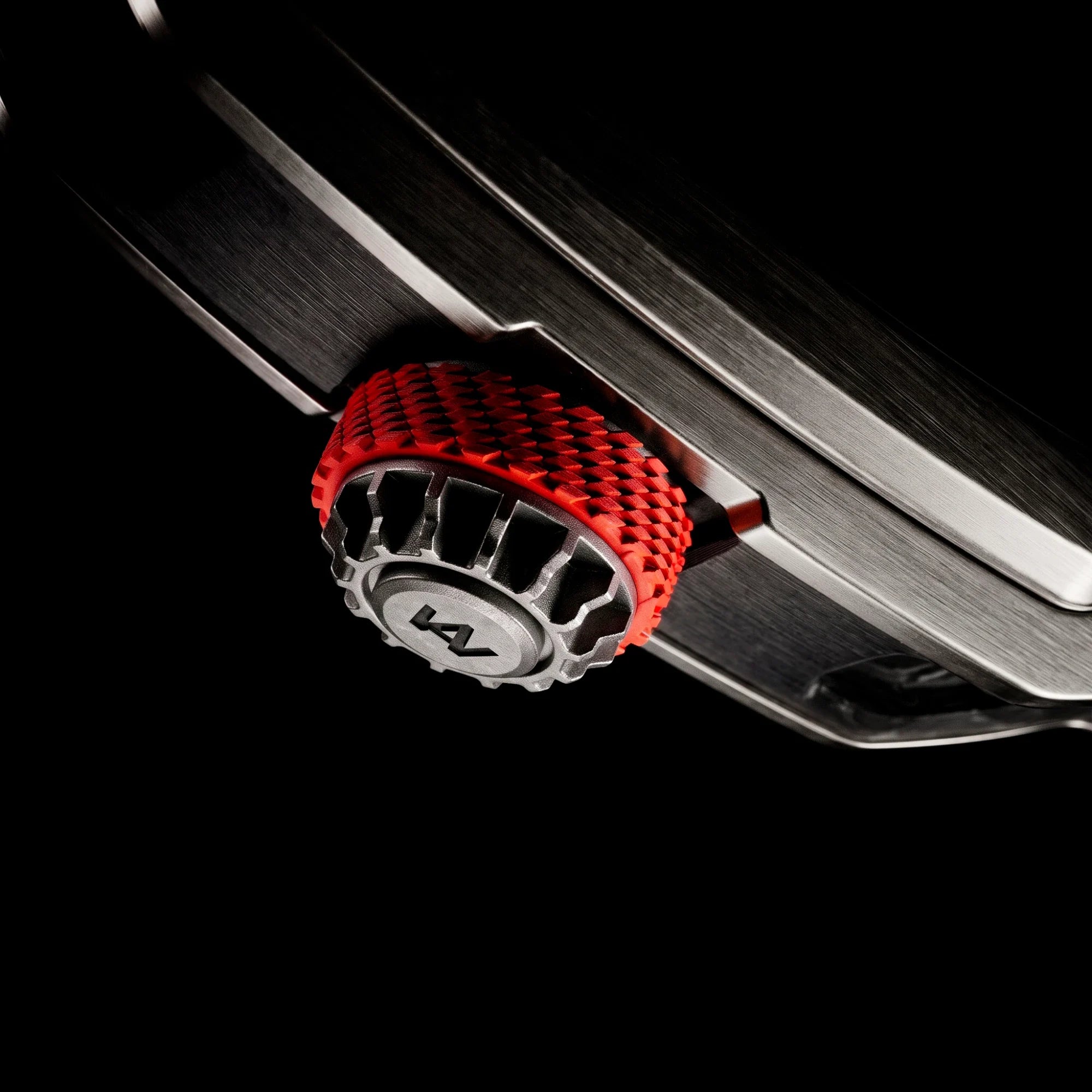 The AGB05 crown from above, in titanium with a red FKM rubber band and engraved logo